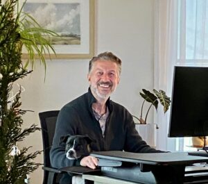 Adi Stelcer, owner of Southern Maine Marketing, with his dog Otis at the farmhouse office in Standish, Maine
